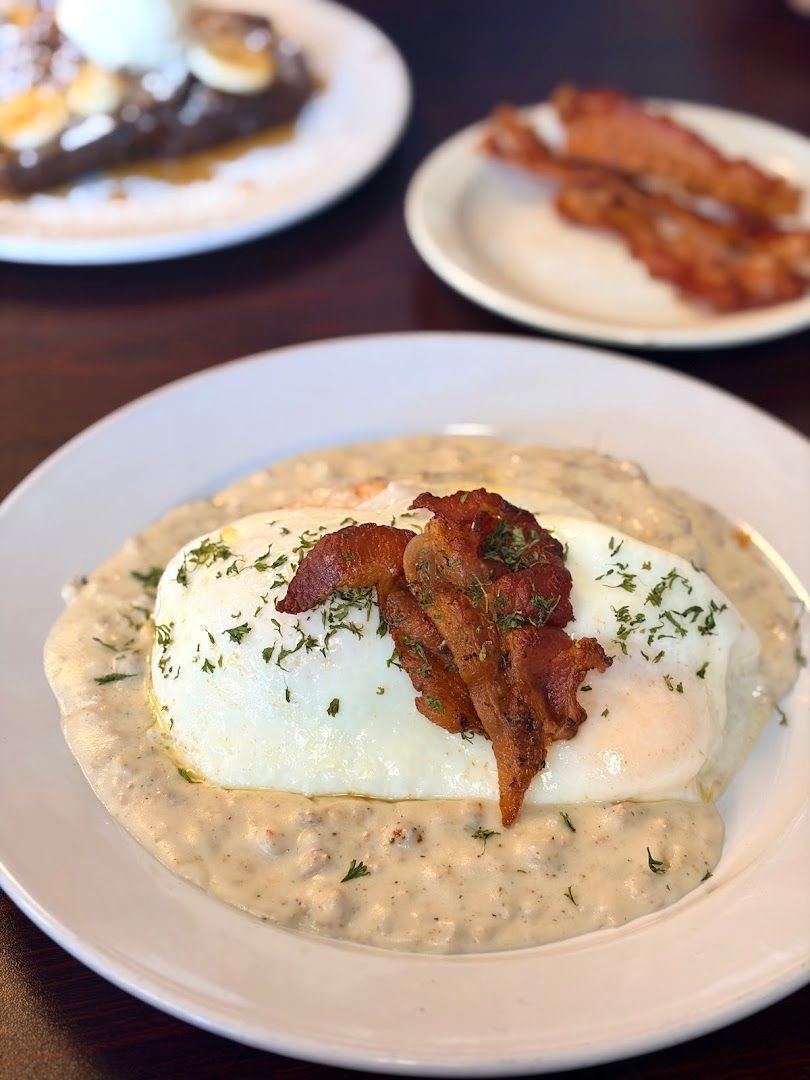 Biscuits and gravy with an egg and bacon