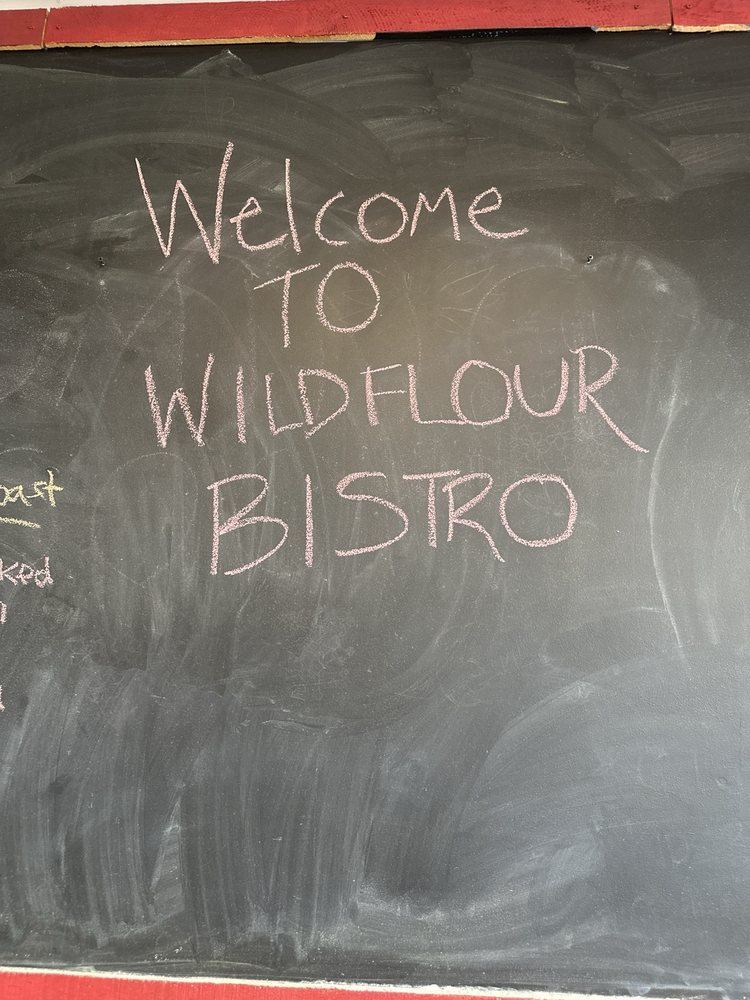 The chalkboard inside the shop that reads Welcome to Wildflour Bistro