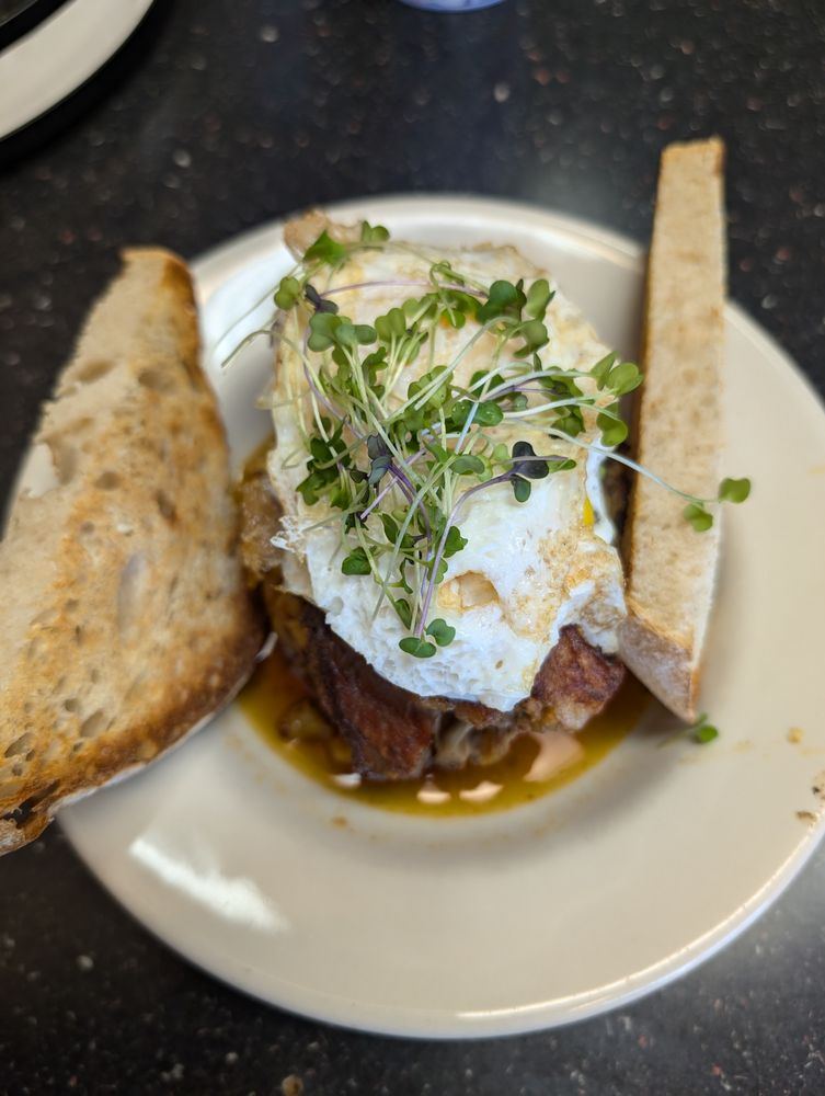 Brisket hash topped with eggs beside sourdough toast
